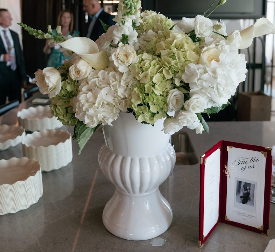 White urn arrangement of hydrangeas, garden roses, and calla lilies at an engagement party