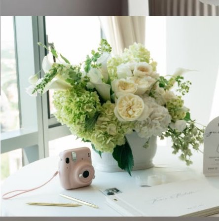 Floral arrangement styled by a window with an instant camera